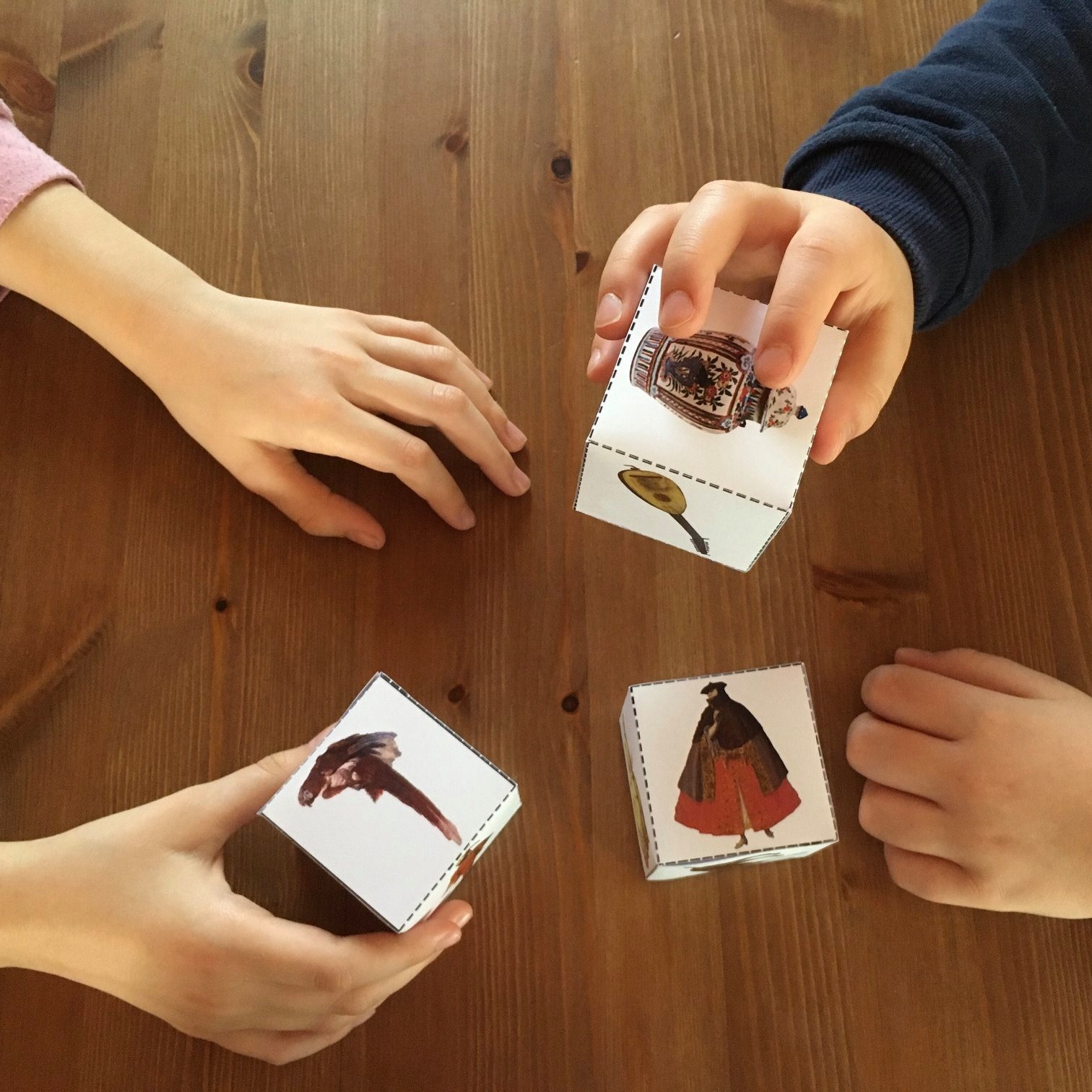 mani che giocano con dei cubi di carta