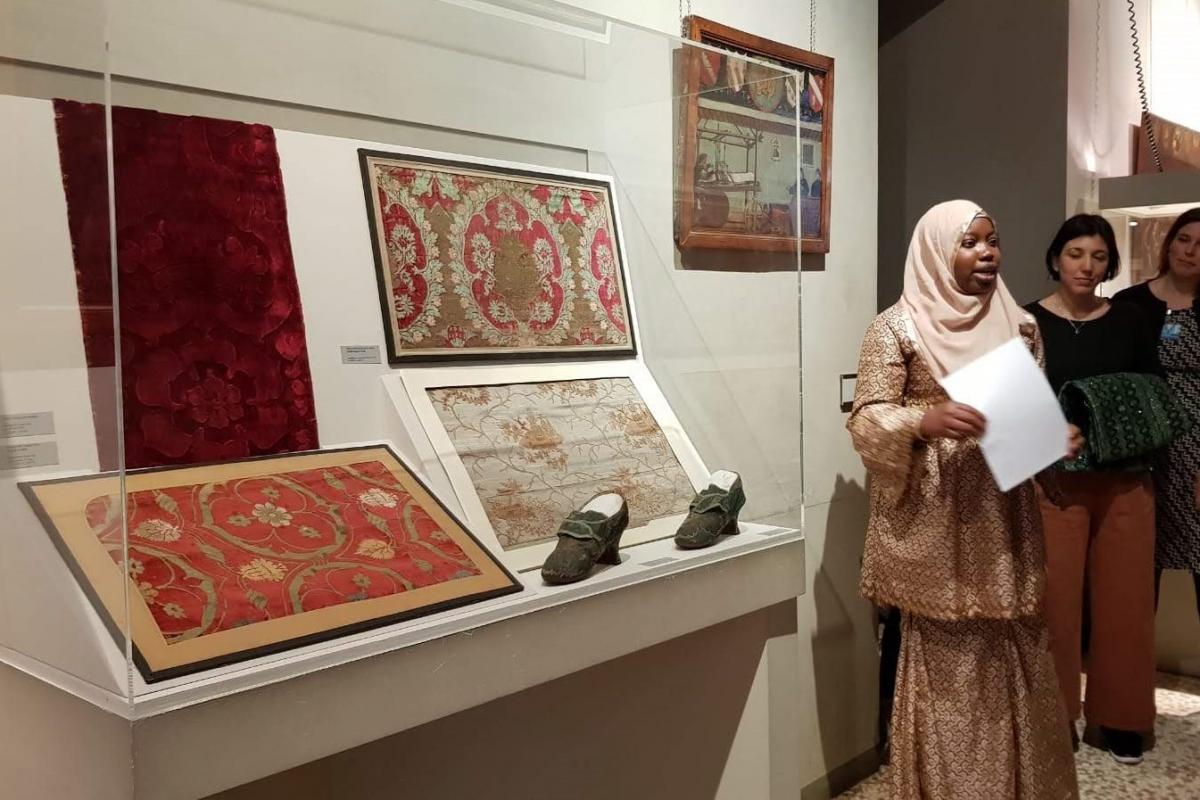 Donna con il velo che parla davanti a un'opera